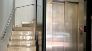 A modern elevator with a metallic finish and a red emergency button. - Petrucci House 2 historic center (Forlì)