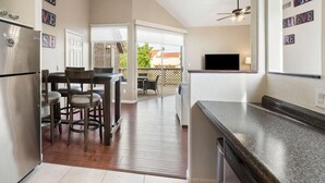 A modern kitchen with a dining area, a large window, and a ceiling fan. - Charming 2-bedroom townhome with fitness room, WiFi in delightful Gilbert (Gilbert)