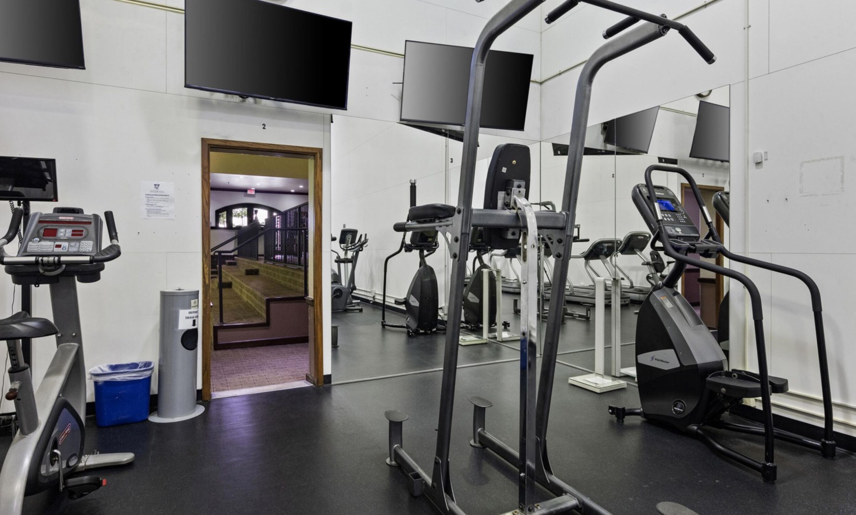 A gym with various exercise equipment, including treadmills and weight machines.