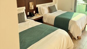 A hotel room with two beds, a wooden headboard, a bedside table with a phone, and a view of the outdoors. - Hotel TamYanJa (Tamiahua)