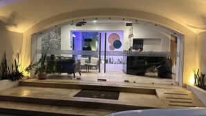 A modern hotel lobby with a curved entrance, a seating area with a sofa and chairs, and a piano. - Hotel TamYanJa (Tamiahua)