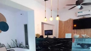 A modern reception area with a black marble counter, a ceiling fan, and pendant lighting. - Hotel TamYanJa (Tamiahua)