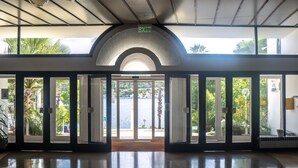 Un hall d’hôtel doté d’une grande porte vitrée donnant sur un magnifique panorama du bord de l’eau.