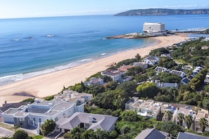 Une zone résidentielle côtière comprenant des maisons, une plage et un grand hôtel.
