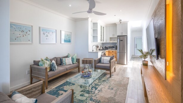A modern living room with a sofa, coffee table, and artwork on the walls. - Villa Rice - Eight Bedroom Villa, Sleeps 16 (Plettenberg Bay)