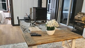 Un salon chaleureux avec une table en bois, un canapé et une cheminée.