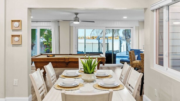 A dining area with a pool table, a ceiling fan, and a view of the pool outside. - 4 Master Suites, Heated Pool, Game Room, King Beds (Indian Rocks Beach)