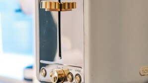 A vintage-style toaster with a control panel featuring buttons labeled "REHEAT" and "DEFROST." - Cozy Studio in Central Locale with Kitchenette (London)