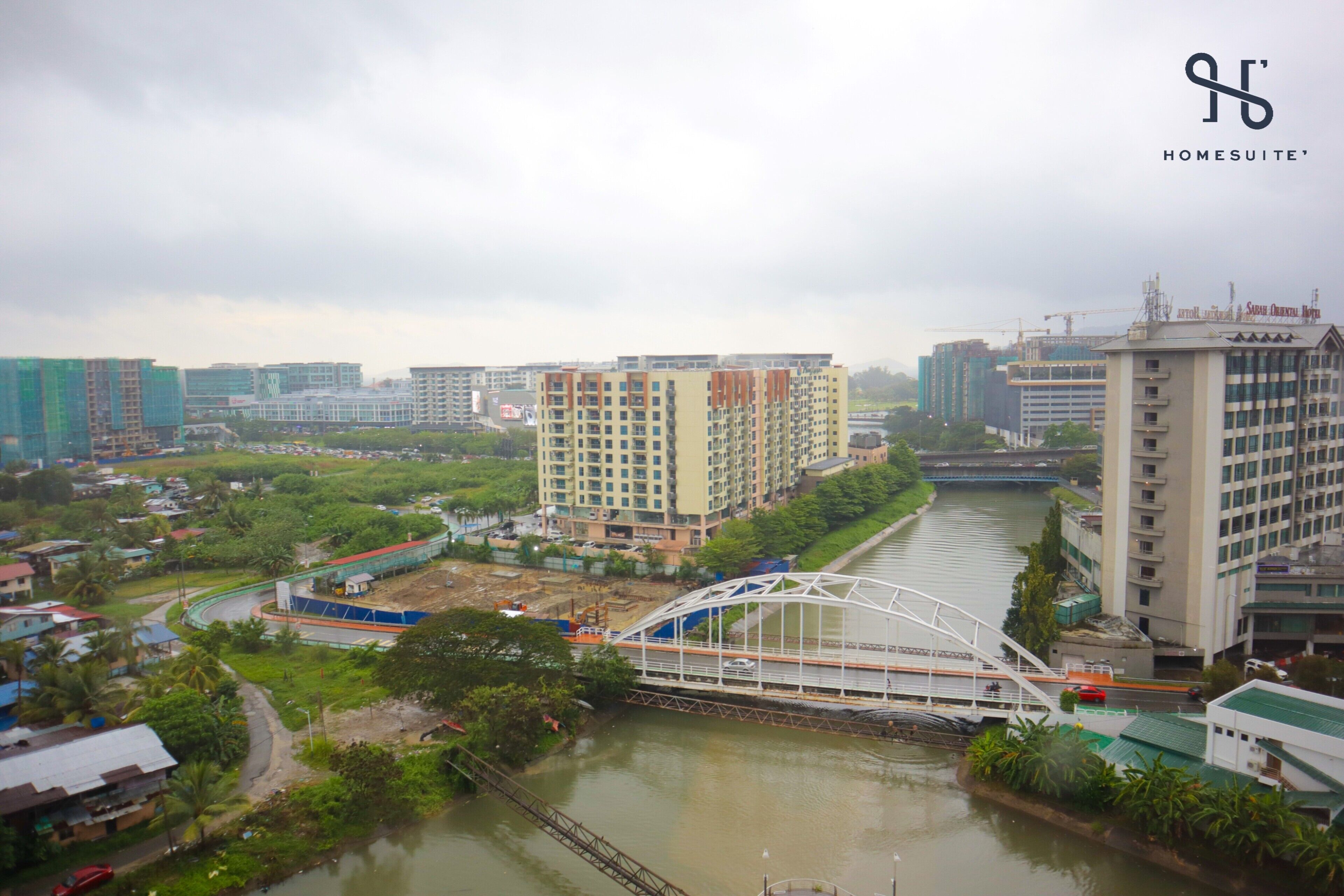 A cityscape with a river, a bridge, and high-rise buildings.