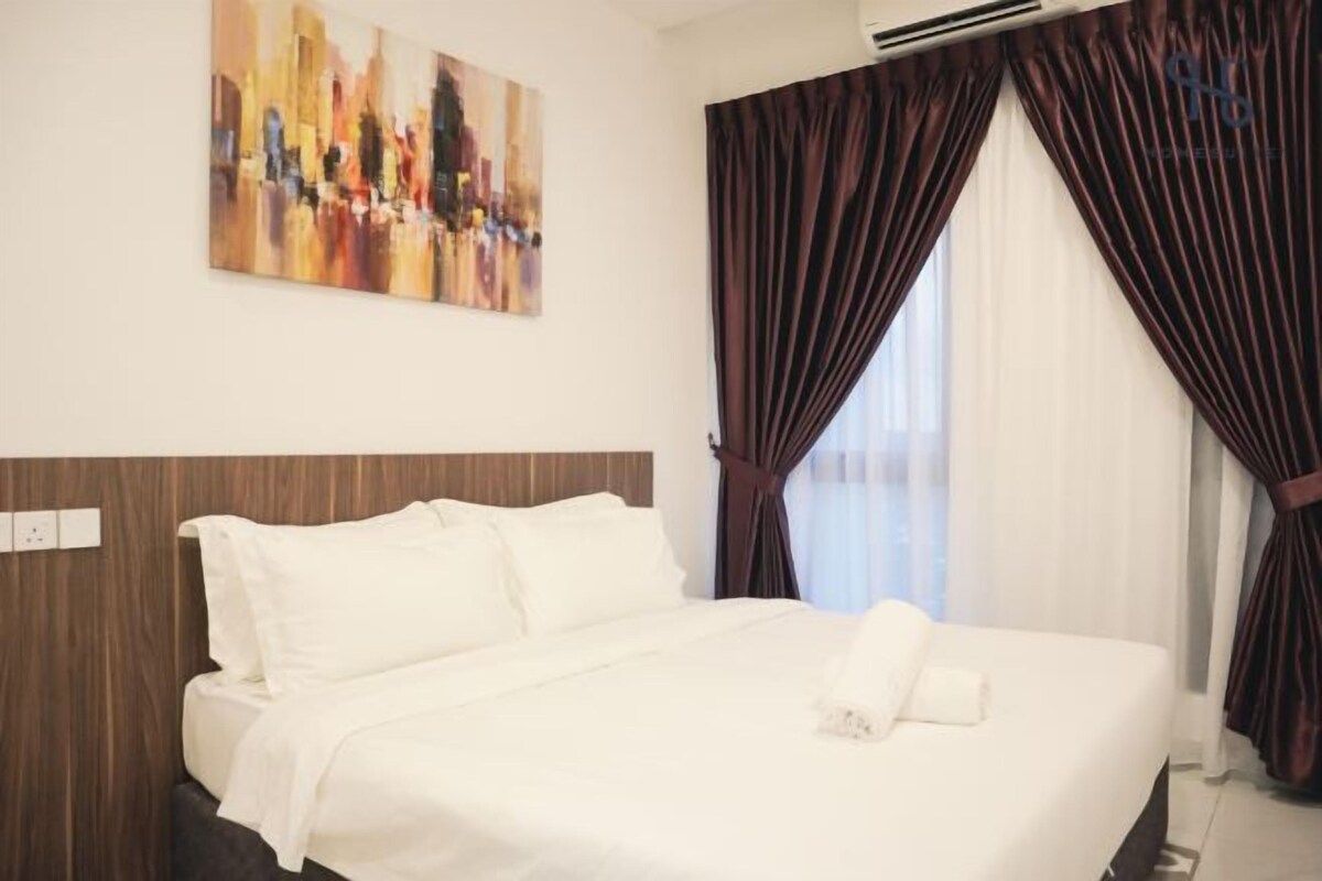 A hotel room with a large bed, dark curtains, a painting on the wall, and a wooden headboard.