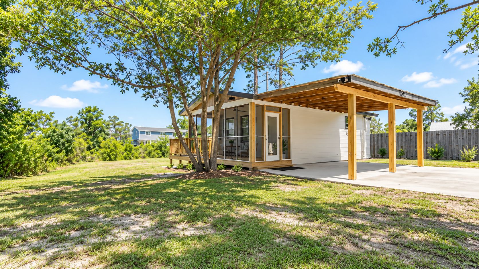 Uma casa moderna com varanda coberta, deck de madeira e gramado.