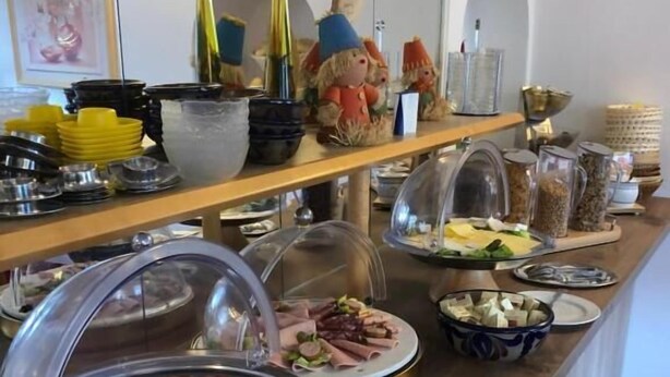 Mostrador de buffet con diversas opciones de comida, incluyendo carnes, ensaladas y salsas.
