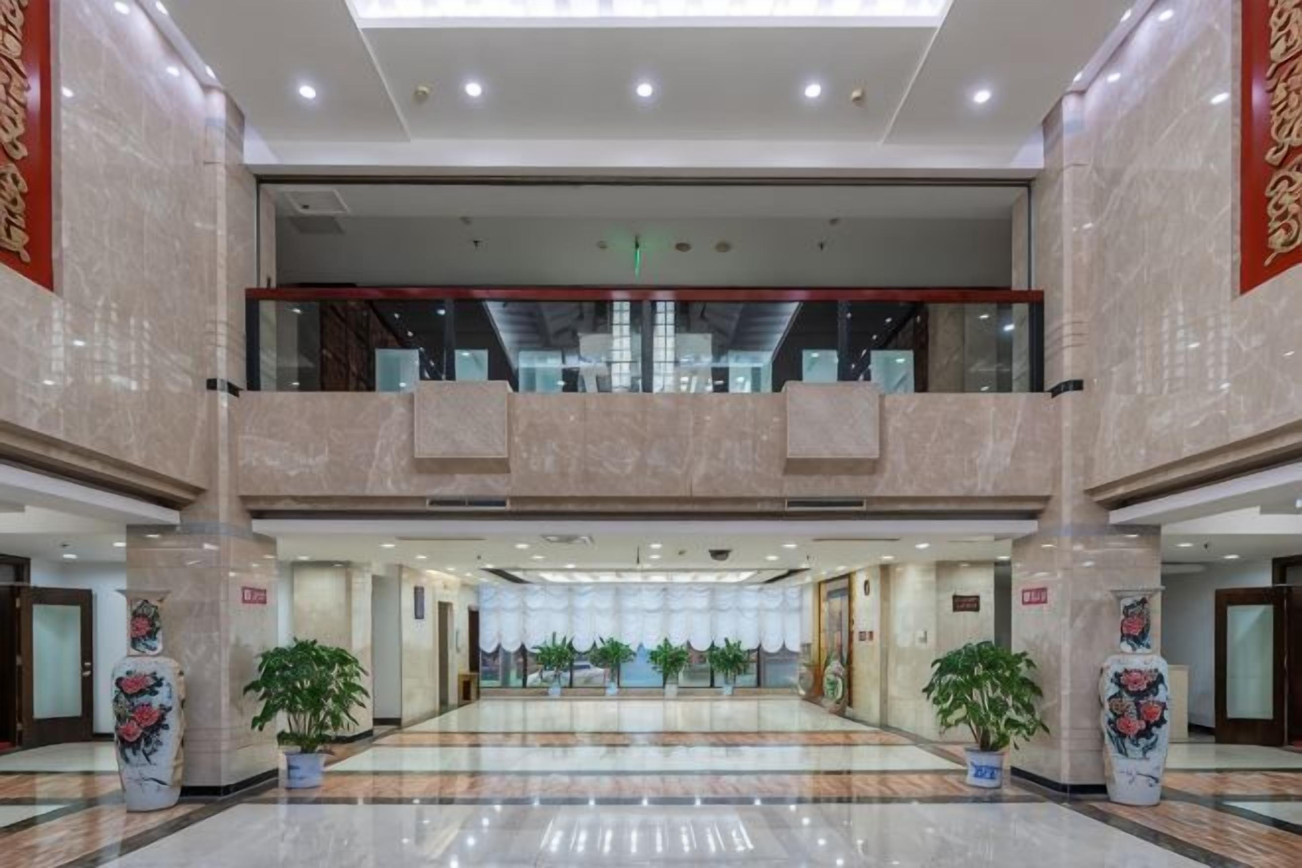 A spacious lobby with a high ceiling, a central atrium, and a mezzanine level.