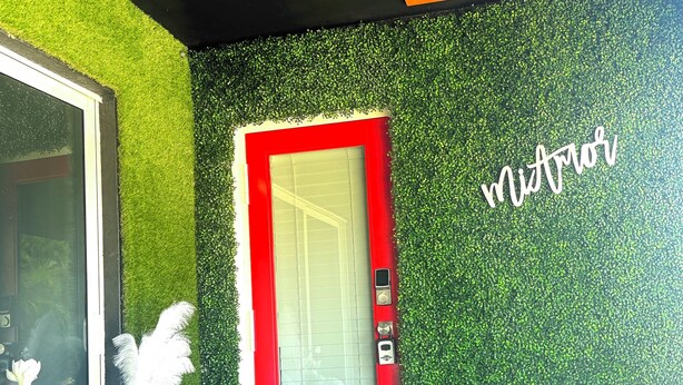 A modern entrance with a red door, green wall, and a sign that reads "Mirador". - The Bright Haven in Cape Coral  (Cape Coral)