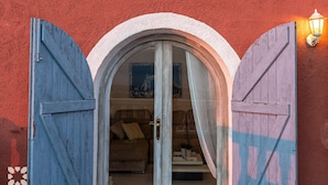 Un vano con dos puertas de madera azul que dan a una habitación con un sofá y una mesita.