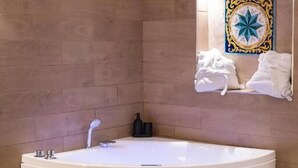 Une salle de bain moderne avec une grande baignoire sur pieds, un miroir fixé au mur et un revêtement mural décoratif en carreaux.