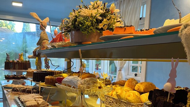 A buffet with various desserts and pastries, including cakes, waffles, and bread. - Pousada dos Anjos (Canela)