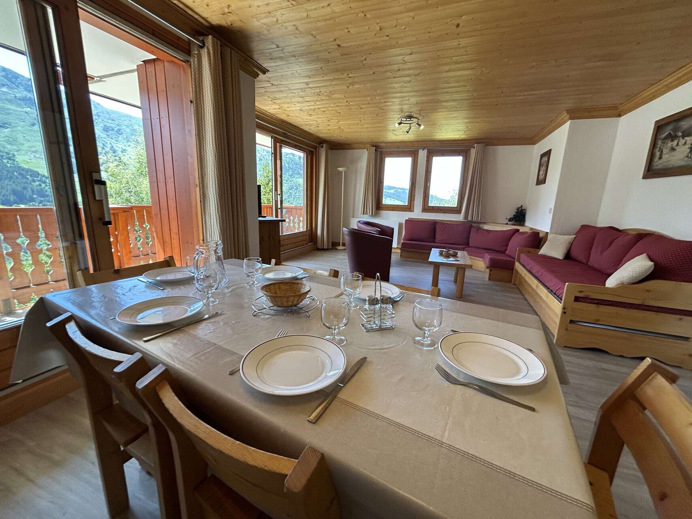 Een eethoek met een tafel gedekt voor vier personen, een bank en uitzicht op de omgeving.