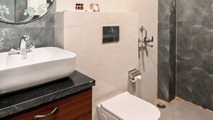 Un bany modern amb un lavabo de marbre, un vàter i una platja de banyera.