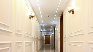 Un passadís llarg i estret amb parets blanques i una porta de fusta al final.