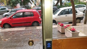 Una puerta con una señal de salida, un picaporte de latón y una placa de metal.