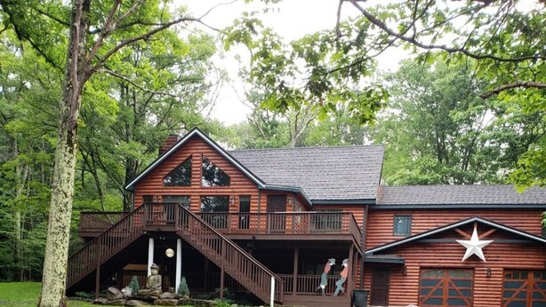 A log cabin with a porch, a staircase, and a garage. - 1 Mile From Ski Slope and Festivals - 125 Nightly Fee (Hunter)
