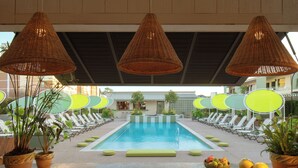 A pool area with lounge chairs, a swimming pool, and potted plants. - The Maidstone New Orleans (New Orleans)