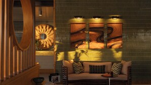 A modern interior with a sofa, patterned cushions, a wooden sideboard, and a large abstract wall art piece. - The Maidstone New Orleans (New Orleans)
