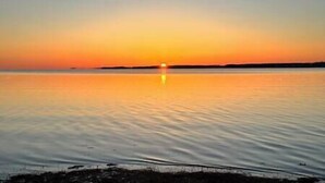 Une étendue d'eau calme où se reflète le coucher de soleil.