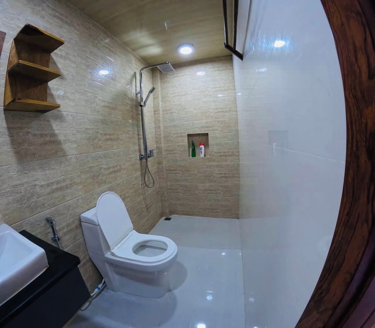 A bathroom with a toilet, a shower, and a sink.