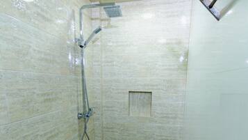 Un baño con inodoro, ducha y piso de baldosas.