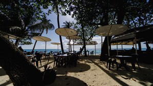 A beachside restaurant with outdoor seating, umbrellas, and a view of the sea. - VelaaVani - Turtle Hive Dhiffushi (Dhiffushi)