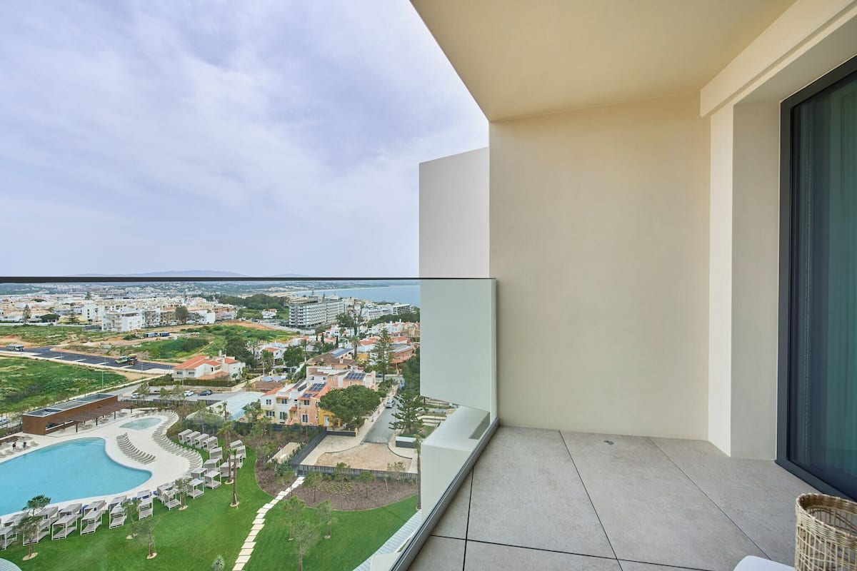 Ein Balkon mit Blick auf einen Pool und die umliegenden Gebäude.