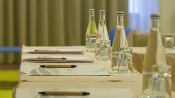 Una mesa de conferencias con documentos, bolígrafos y botellas de agua.