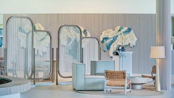 A modern interior with seating arrangements, a decorative wall, and a floor lamp.