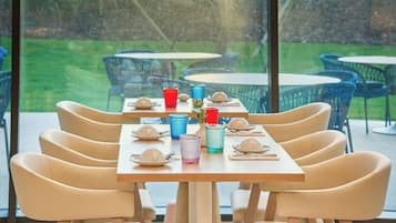 Un comedor con una larga mesa dispuesta para seis personas, rodeada por seis sillas.