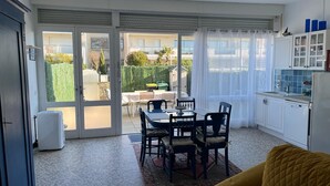A compact kitchen with a dining area, large windows, and a view of the outside. - Charming ground-floor apartment 150m from the beach  (Saint-Georges-de-Didonne)