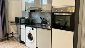 A compact kitchen with a built-in washer, a microwave, and an oven.