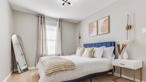 Un dormitorio con cama, mesita de noche y espejo.