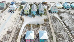 Vista aérea de una zona residencial costera con casas, una playa y una carretera.