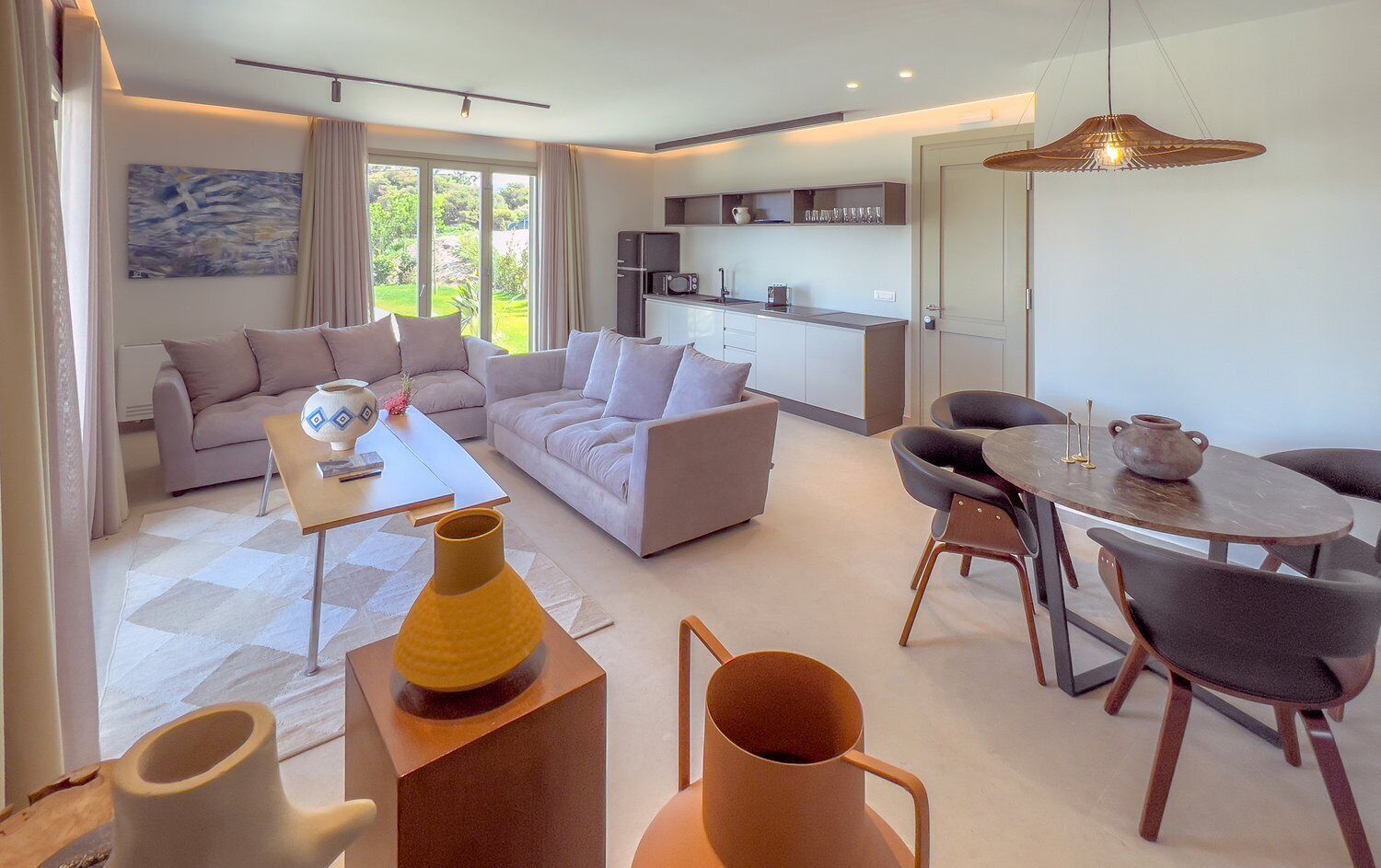 Een moderne woonkamer met een zithoek, een salontafel en een eethoek met tafel en stoelen.