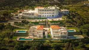 Un grand immeuble à plusieurs étages, doté d’une cour intérieure et de plusieurs piscines.