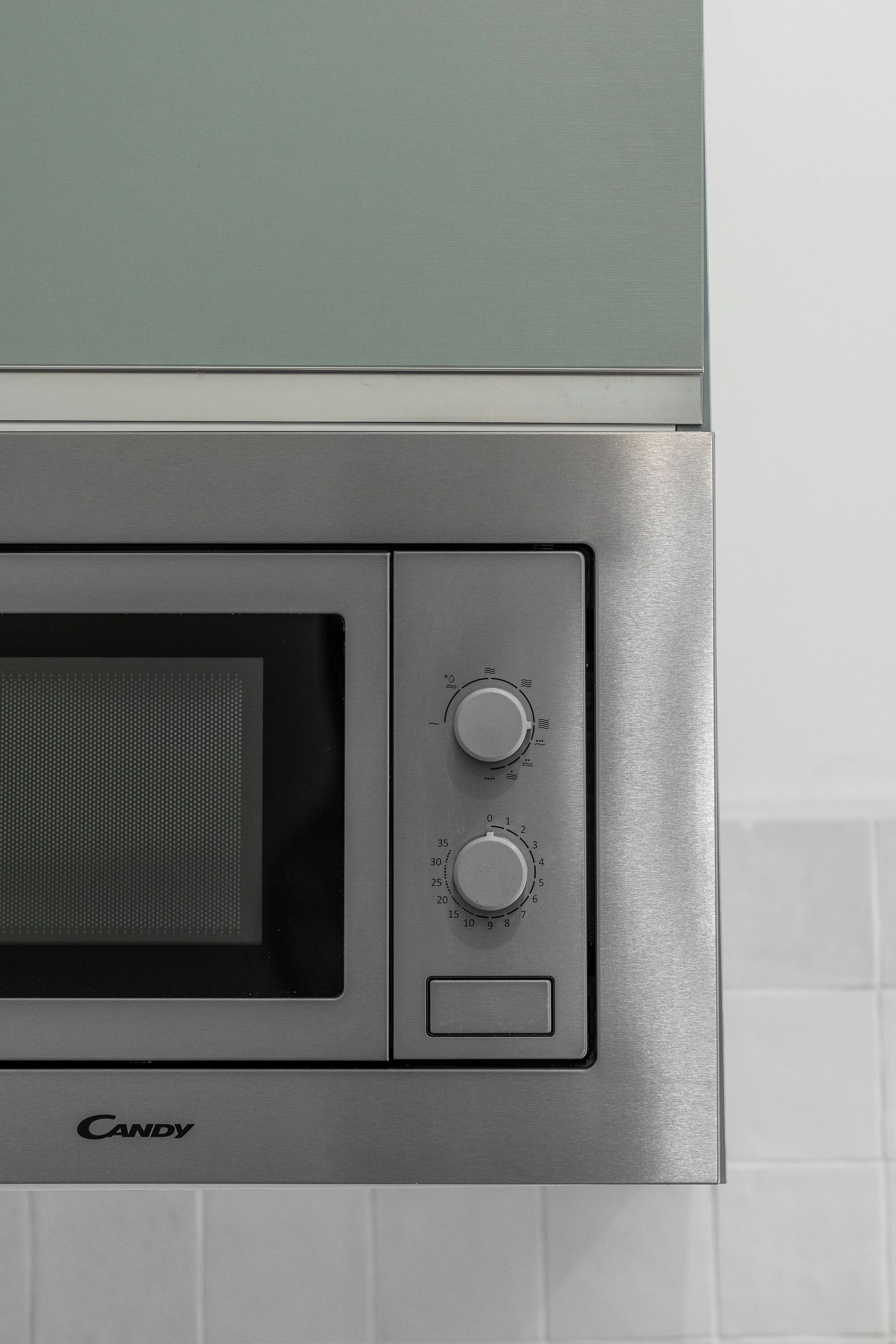 A microwave oven with a control panel, including two dials and a power button.