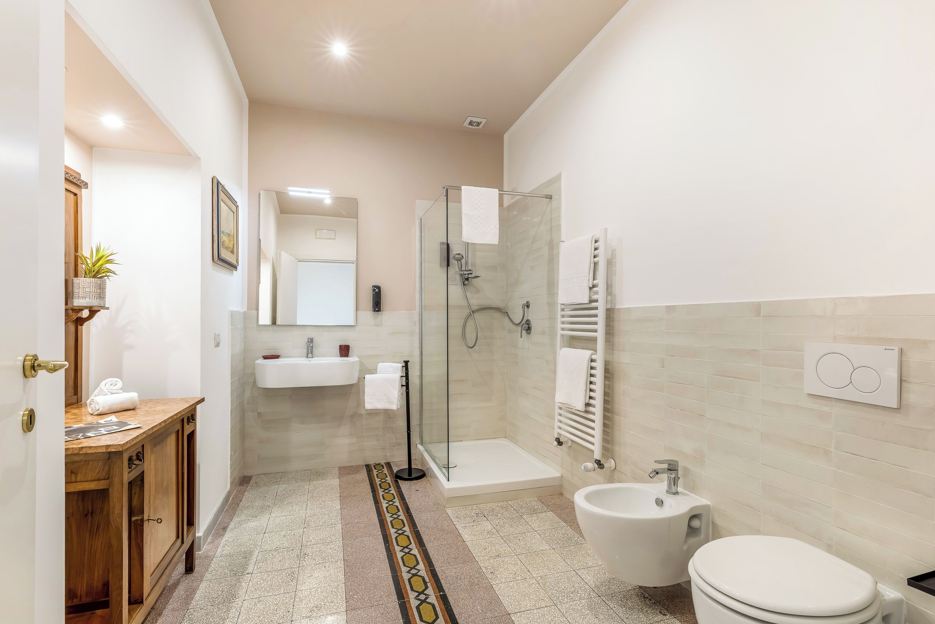 Une salle de bain moderne équipée d’une douche, de toilettes, d’un lavabo et d’un meuble-lavabo en bois.