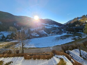 A snow-covered landscape with a road, buildings, and mountains in the background. - Mountain-view Apartment in Bad Kleinkirchheim (Bad Kleinkirchheim)