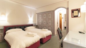 A hotel room with two beds, a wardrobe, a desk, and a mirror. - Chalet Stadio (Cortina d'Ampezzo)