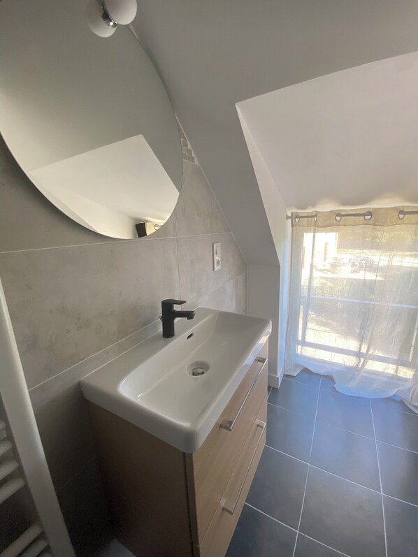 A bathroom with a white sink, a mirror, and a shower curtain.