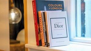 Une bibliothèque contenant des livres, notamment « Les couleurs de Londres » et un ouvrage sur Dior.