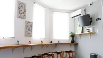 Una habitació moderna i ben il·luminada amb una taula de fusta llarga, diverses cadires i obres d'art a les parets.