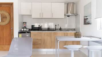 Apartamento família, vista para a cidade | Cozinha privada | Geladeira, micro-ondas, cooktop, talheres/pratos/utensílios de cozinha